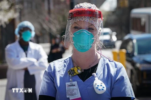 Nhân viên y tế đeo khẩu trang N95 và các thiết bị bảo hộ nhằm ngăn virus SARS-CoV-2 gây dịch COVID-19 tại New York, Mỹ. (Ảnh: AFP/TTXVN)