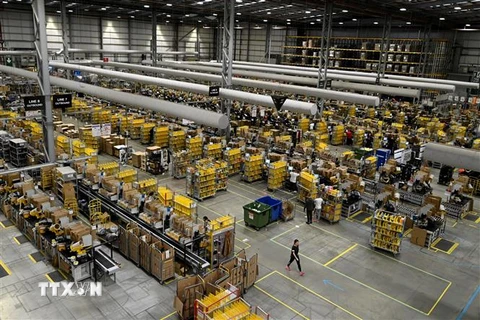 Nhân viên đóng gói hàng hóa cho khách hàng tại một trung tâm dịch vụ của Amazon. (Ảnh: AFP/TTXVN)