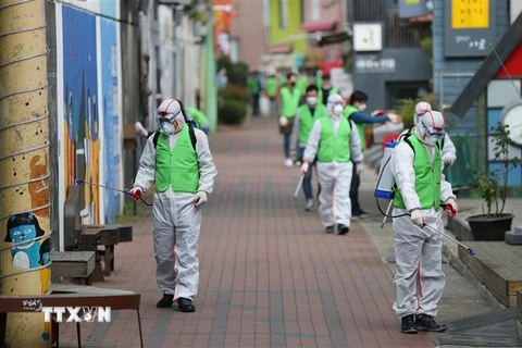Nhân viên y tế phun khử trùng đường phố nhằm ngăn chặn sự lây lan của dịch COVID-19 tại Daegu, Hàn Quốc. (Ảnh: Yonhap/TTXVN)