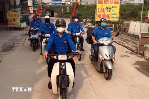 Đoàn viên, thanh niên tỉnh Bắc Giang trên chiếc xe máy gắn loa di động đi khắp các ngõ xóm để tuyên truyền về dịch bệnh COVID-19. (Ảnh: Thúy Phương/TTXVN)