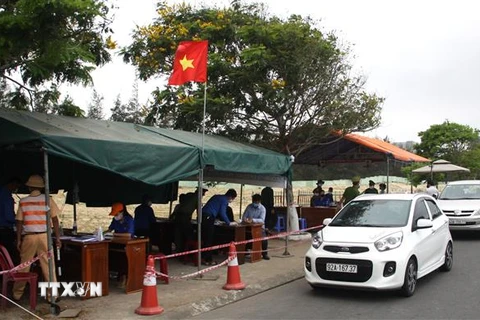 Các đoàn viên thanh niên tham gia hỗ trợ các lực lượng chức năg tại chốt kiểm soát trên tuyến đường ven biển tỉnh Quảng Nam tiếp giáp với thành phố Đà Nẵng. (Ảnh: Trịnh Bang Nhiệm/TTXVN)