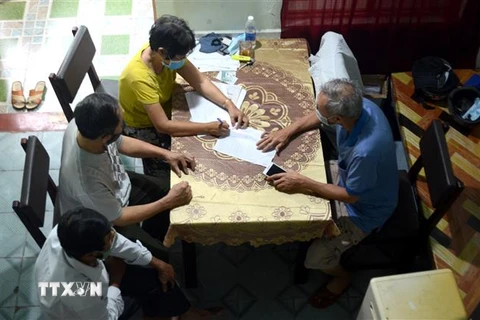 Các cán bộ tổ dân phố Phường Thanh Khê Tây, quận Thanh Khê, Đà Nẵng, ghi chép thông tin tại một trong những hộ có hoàn cảnh khó khăn. (Ảnh: Quốc Dũng/TTXVN)