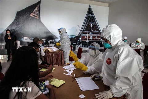 Nhân viên y tế xét nghiệm nhanh COVID-19 cho người lao động nhập cư tại Bắc Sumatra, Indonesia. (Ảnh: THX/TTXVN)
