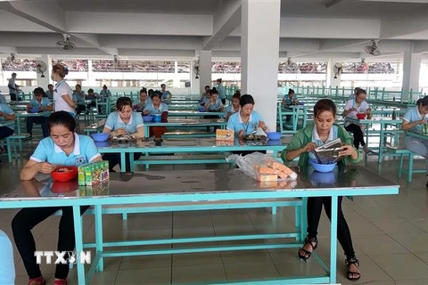 Công nhân ngồi đúng khoảng cách trong nhà ăn để phòng dịch bệnh lây lan. (Ảnh: TTXVN phát)