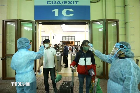 Hành khách được đo thân nhiệt trước khi vào ga Hà Nội. (Ảnh: Minh Quyết/TTXVN)