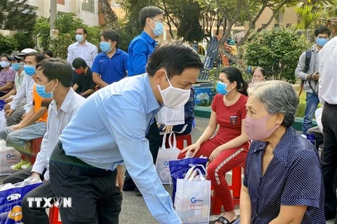 Ông Nguyễn Mạnh Cường, Bí thư quận ủy Thủ Đức, thăm hỏi, trao quà hỗ trợ người dân gặp khó khăn do dịch bệnh. (Ảnh: TTXVN phát)