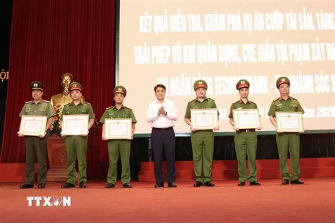 Chủ tịch UBND Hà Nội Nguyễn Đức Chung trao Bằng khen cho các cá nhân có thành tích xuất sắc. (Ảnh: Doãn Tấn/TTXVN)