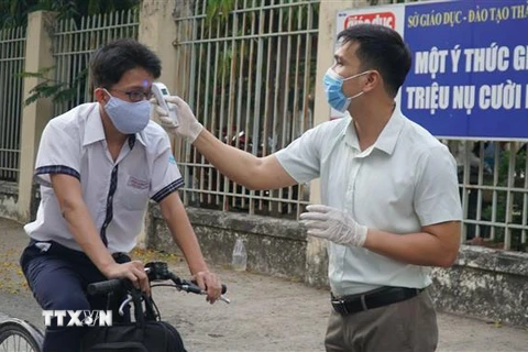 Học sinh Trường THPT Trần Văn Giàu, quận Bình Thạnh được đo thân nhiệt trước khi vào trường. (Ảnh: Xuân Anh/TTXVN)