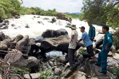 Lực lượng cứu hộ tìm kiếm nạn nhân bị nước lũ cuốn trôi tại thác Liêng Ệp. (Nguồn: Báo Lâm Đồng)