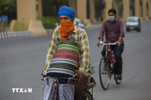 Người dân đeo khẩu trang phòng lây nhiễm COVID-19 tại New Delhi, Ấn Độ. (Ảnh: THX/TTXVN)