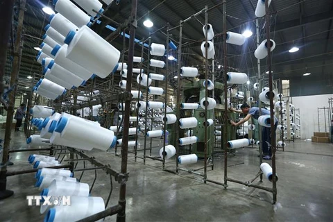 Công nhân làm việc tại nhà máy sợi Huế thuộc Công ty Cổ phần Dệt may Huế (Thừa Thiên-Huế). (Ảnh: TTXVN)