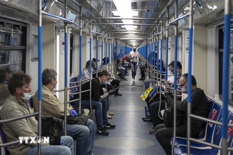 Hành khách đeo khẩu trang và găng tay phòng lây nhiễm COVID-19 trên tàu điện ngầm ở Moskva, Nga. (Ảnh: THX/TTXVN)