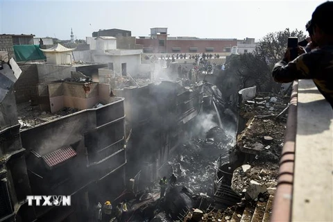 Lực lượng cứu hộ làm nhiệm vụ tại hiện trường vụ rơi máy bay chở khách ở thành phố Karachi, miền Nam Pakistan. (Ảnh: AFP/TTXVN)
