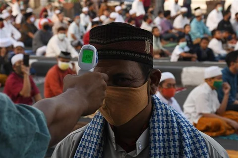 Kiểm tra thân nhiệt phòng COVID-19 trước buổi lễ cầu nguyện Eid al-Fitr, Jakarta, Indonesia. (Ảnh: THX/TTXVN)