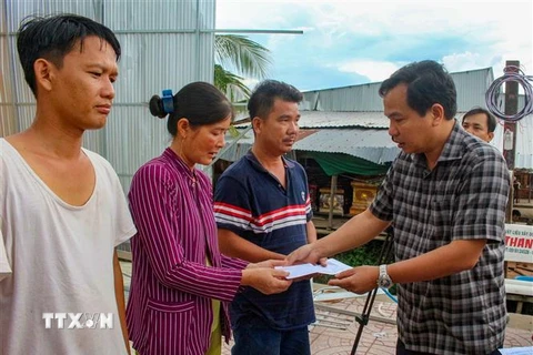 Chủ tịch UBND thành phố Cần Thơ Lê Quang Mạnh trao tiền hỗ trợ cho người dân bị thiệt hại do thiên tai ở huyện Thới Lai. (Ảnh: TTXVN phát)