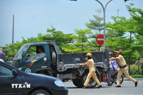 Các chiến sỹ Cảnh sát giao thông thành phố Ninh Bình đẩy xe giúp người dân khi sẩy ra sự cố. (Ảnh: Minh Đức/TTXVN)