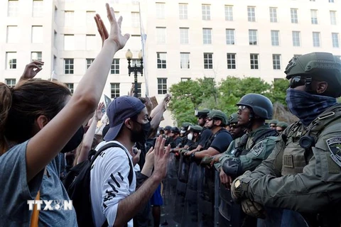 Cảnh sát được triển khai để ngăn người biểu tình quá khích trong cuộc tuần hành phản đối hành động của cảnh sát dẫn đến cái chết của người da màu George Floyd, tại Washington, DC. (Ảnh: AFP/TTXVN)