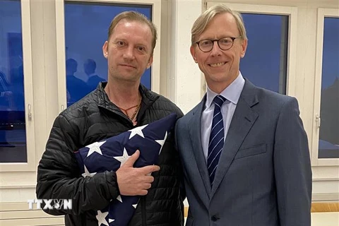 Cựu binh hải quân Mỹ Michael White (trái) chụp ảnh cùng Đặc phái viên Mỹ về vấn đề Iran Brian Hook (phải) tại sân bay Zurich, Thụy Sĩ sau khi ông White được chính quyền Tehran trả tự do ngày 4/6. (Ảnh: AFP/TTXVN)
