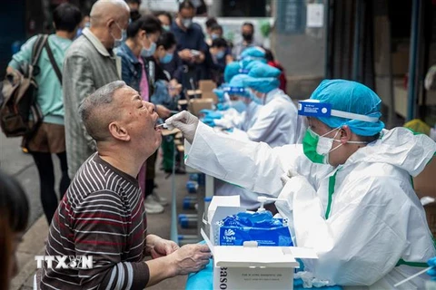 Nhân viên y tế lấy mẫu dịch xét nghiệm COVID-19 cho người dân tại Vũ Hán, tỉnh Hồ Bắc, Trung Quốc. (Ảnh: AFP/ TTXVN)