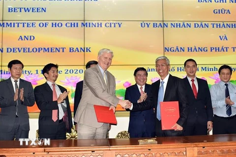 Ông Võ Văn Hoan, Phó Chủ tịch UBND Thành phố Hồ Chí Minh (phải) và ông Eric Sidgwick, Giám đốc ADB tại Việt Nam (trái) ký Bản ghi nhớ hợp tác giữa hai bên. (Ảnh: Xuân Khu/TTXVN)