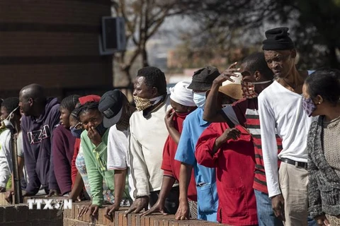 Người dân xếp hàng chờ nhận thực phẩm và hàng hóa cứu trợ tại Johannesburg, Nam Phi trong bối cảnh dịch COVID-19 lan rộng. (Ảnh: THX/TTXVN)