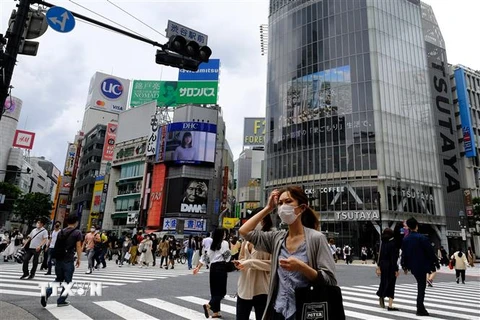 Người dân đeo khẩu trang phòng lây nhiễm COVID-19 trên một đường phố ở Tokyo, Nhật Bản. (Ảnh: AFP/TTXVN)