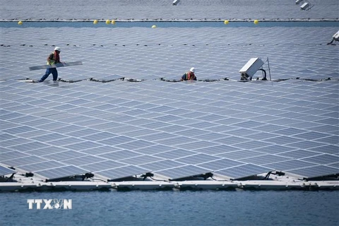 Nhân viên kỹ thuật làm việc tại nhà máy năng lượng Mặt trời nổi đầu tiên tại thành phố miền Đông Nam Piolenc, Pháp. (Ảnh: AFP/TTXVN)