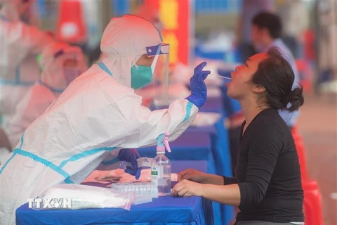 Nhân viên y tế xét nghiệm COVID-19 cho người dân tại Vũ Hán, tỉnh Hồ Bắc, Trung Quốc. (Ảnh: THX/TTXVN)