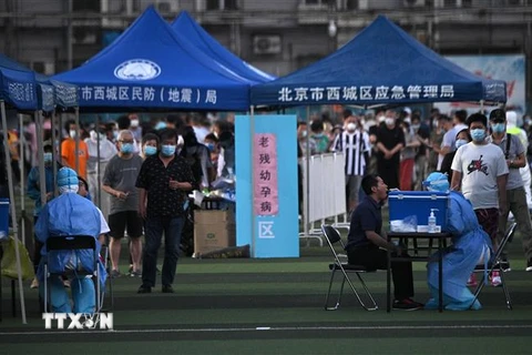 Xét nghiệm nhằm phát hiện người nhiễm COVID-19 cho người dân sống gần khu chợ đầu mối thực phẩm Tân Phát Địa ở Bắc Kinh. (Ảnh: AFP/TTXVN)