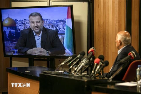 Quan chức cấp cao phong trào Fatah, Jibril Rajub (phải) tại thành phố Ramallah trong cuộc họp trực tuyến với quan chức phái Hamas, ông Saleh al-Arouri (trên màn hình) ở Beirut (Lebanon) ngày 2/7. (Ảnh: AFP/TTXVN)
