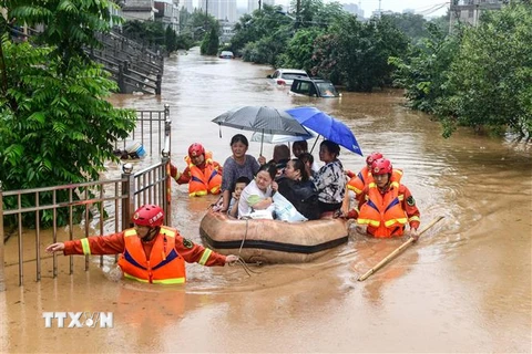 Sơ tán người dân khỏi các khu ngập lụt tại tỉnh Giang Tây, Trung Quốc. (Ảnh: AFP/TTXVN)