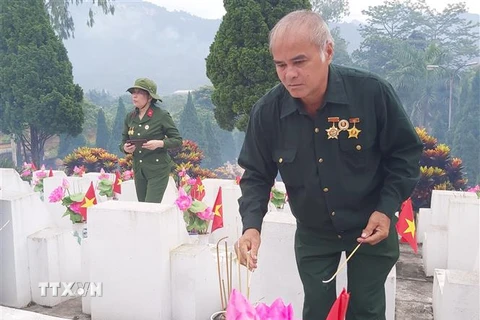 Ông Mai Đức Ngời, cựu chiến binh mặt trận Vị Xuyên, thắp hương cho đồng đội tại Nghĩa trang Liệt sỹ quốc gia Vị Xuyên. (Ảnh: Nguyễn Chiến/TTXVN)