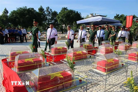 Lãnh đạo tỉnh Long An cùng các đại biểu thực hiện nghi thức an táng hài cốt liệt sỹ. (Ảnh: Bùi Giang/TTXVN)