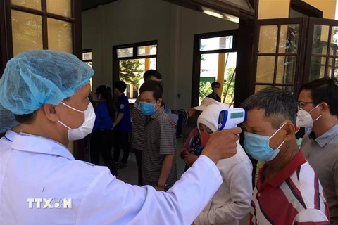 Hành khách đi trên những phương tiện giao thông tiến hành kiểm tra thân nhiệt, khai báo y tế tại chốt kiểm tra thị xã Hương Thủy, tỉnh Thừa Thiên-Huế. (Ảnh: Đỗ Trưởng/TTXVN)