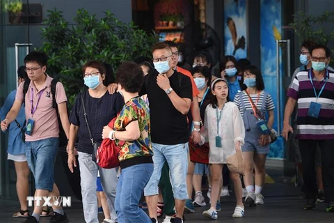 Người dân đeo khẩu trang phòng lây nhiễm virus corona tại Hong Kong, Trung Quốc. (Ảnh: AFP/TTXVN)