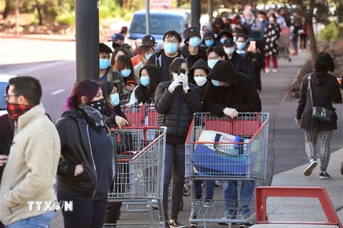 Người dân xếp hàng chờ mua hàng hóa tại siêu thị ở Melbourne, Australia trước khi lệnh giới nghiêm do COVID-19 được ban bố. (Ảnh: AFP/TTXVN)