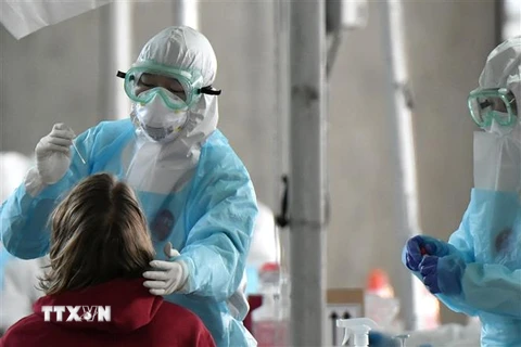 Nhân viên y tế lấy mẫu xét nghiệm COVID-19 tại Incheon, Hàn Quốc. (Ảnh: AFP/TTXVN)