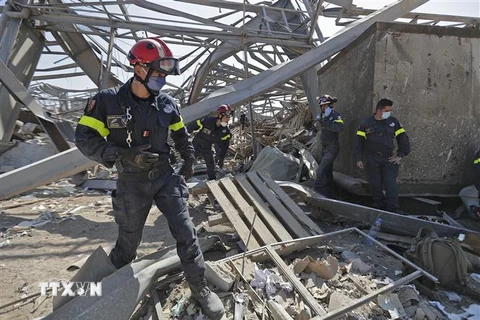 Nhân viên cứu hộ đến từ Pháp tìm kiếm nạn nhân dưới đống đổ nát sau vụ nổ ở Beirut, Liban. (Ảnh: AFP/TTXVN)