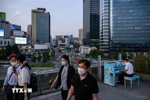 Người dân đeo khẩu trang phòng lây nhiễm COVID-19 tại Seoul, Hàn Quốc. (Ảnh: AFP/TTXVN)