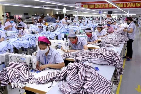 Gia công sản phẩm quần áo bảo hộ lao động và áo sơ mi xuất khẩu sang thị trường Hàn Quốc. (Ảnh: Vũ Sinh/TTXVN)
