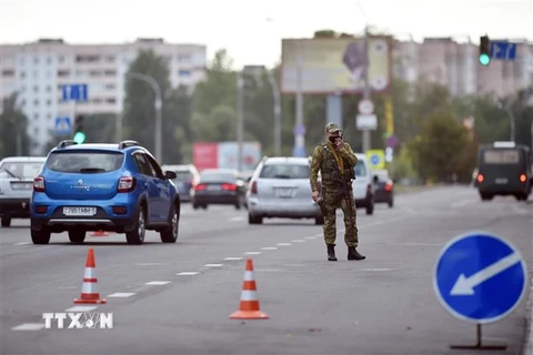 Lực lượng an ninh Belarus gác tại điểm kiểm soát trên một tuyến đường ở ngoại ô thủ đô Minsk. (Ảnh: AFP/TTXVN)