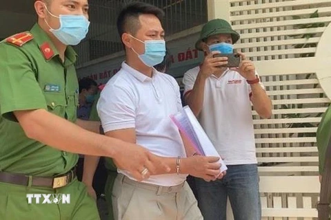 Lực lượng công an áp giải ông Tùng sau khi đọc lệnh bắt giữ. (Ảnh: TTXVN phát)