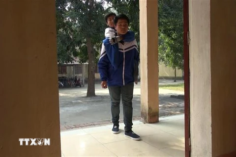 Em Ngô Minh Hiếu đã thay đôi chân đưa người bạn khuyết tật Nguyễn Tất Minh hàng ngày đến trường. (Ảnh: Khiếu Tư/TTXVN)