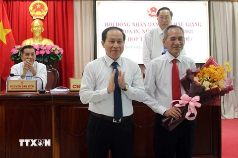 Ông Lê Tiến Châu, Chủ tịch UBND tỉnh Hậu Giang (bên trái) tặng hoa cho ông Lữ Văn Hùng. (Ảnh: Duy Khương/TTXVN)