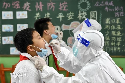 Nhân viên y tế lấy mẫu xét nghiệm COVID-19 cho người dân tại tỉnh Hà Bắc, Trung Quốc. (Ảnh: AFP/TTXVN)
