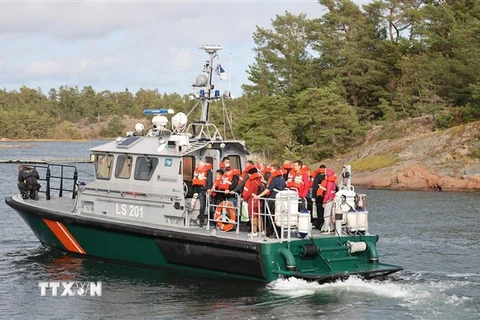 Hành khách được sơ tán từ phà bị mắc cạn tại một đảo trên biển Baltic. (Ảnh: AFP/TTXVN)