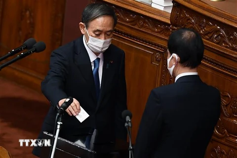 Tân Chủ tịch đảng Dân chủ Tự do (LDP) cầm quyền Yoshihide Suga (trái) bỏ phiếu tại phiên họp Quốc hội Nhật Bản ở Tokyo. (Ảnh: AFP/TTXVN)