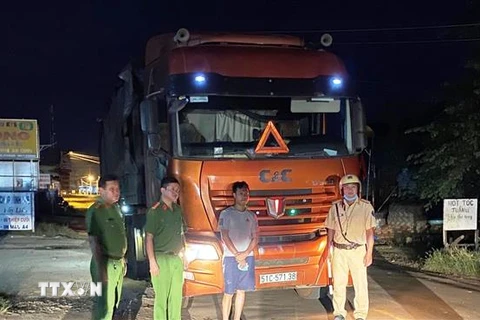 Tài xế Nguyễn Văn Tú và xe tải chở phế liệu nhập lậu bị lực lượng chức năng bắt giữ. (Ảnh Lê Đức Hoảnh/TTXVN)