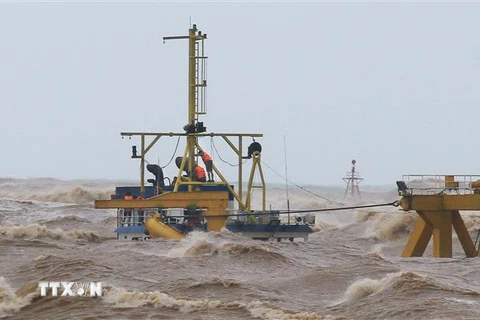Các thuyền viên trên tàu Vietship 01 bị mắc kẹt ở vị trí gần phao số 0 khu vực cảng Cửa Việt. (Ảnh: Hồ Cầu/TTXVN)