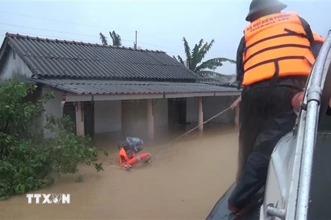 Bộ đội Biên phòng tỉnh Quảng Trị di dời những người dân bị mắc kẹt trong lũ đến nơi an toàn. (Ảnh: Hồ Cầu/TTXVN)